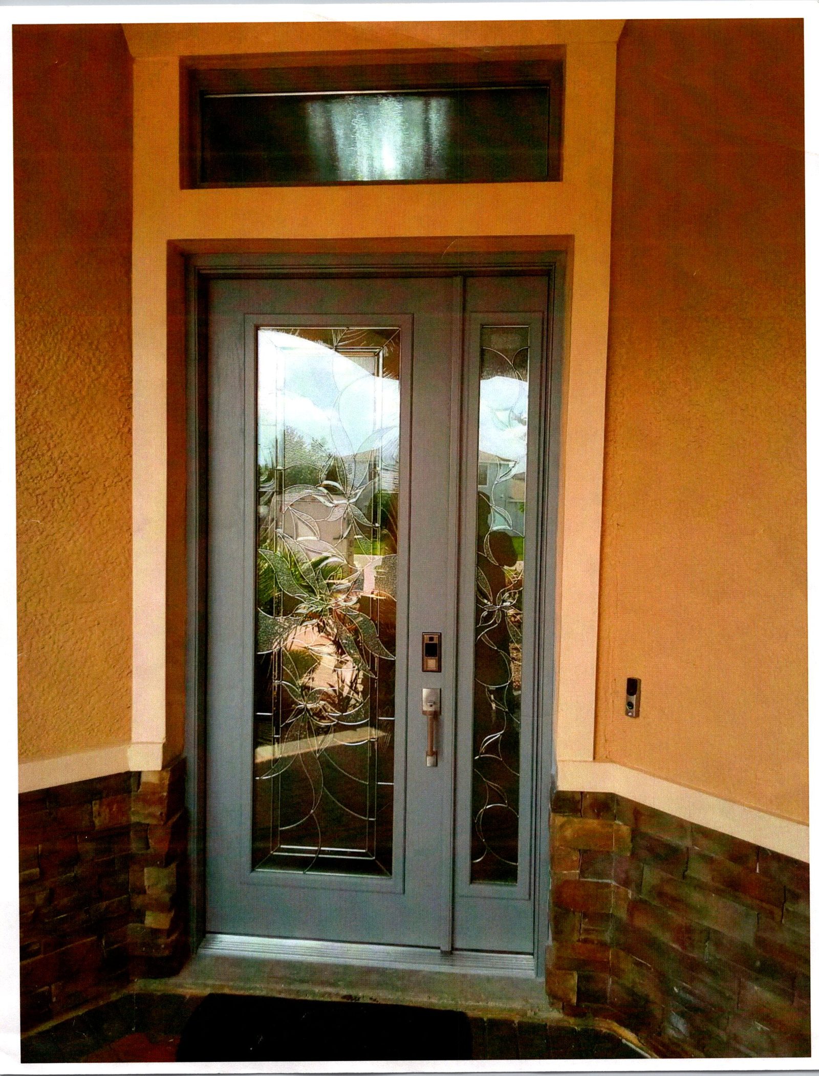 Double front entry doors with impact glass inserts and transom installed on a Florida home